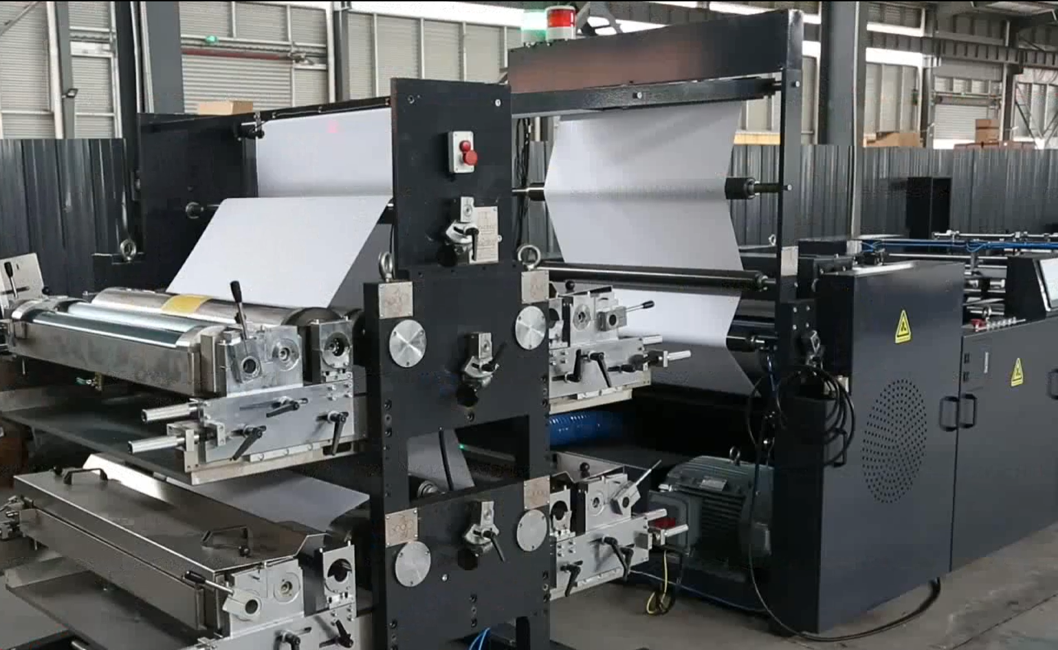 alt：Modern paper sheeting machine manufacturing factory with production equipment, skilled workers, and organized workshop environment